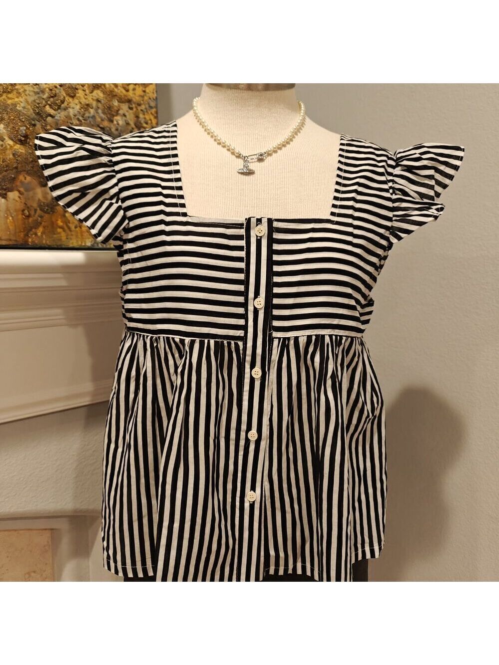 Lightweight and breathable striped blouse with flutter sleeves.